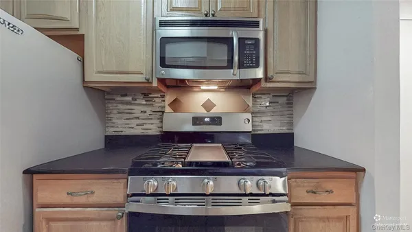 a stove top oven sitting inside of a kitchen
