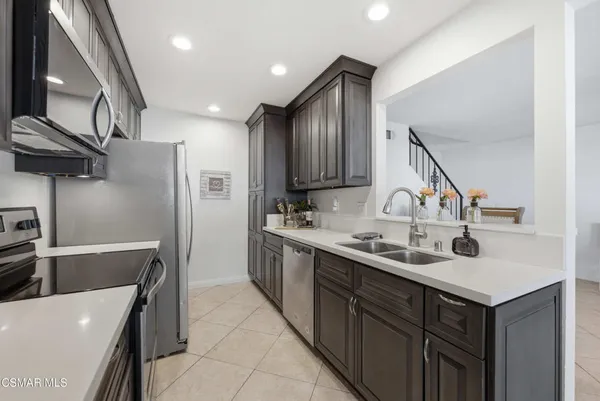 a kitchen with stainless steel appliances a sink and a refrigerator