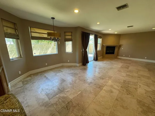 a view of an empty room with a fireplace and a window