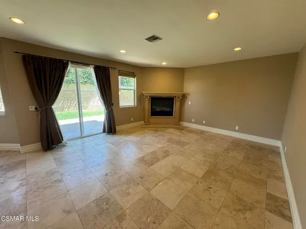 a view of an empty room with a fireplace and a large window