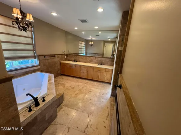 a room with kitchen island stainless steel appliances a stove a sink and a refrigerator