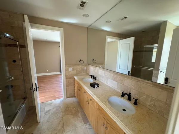 a bathroom with a tub sink and mirror