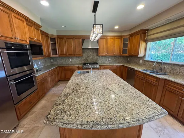 a kitchen with sink a microwave and cabinets