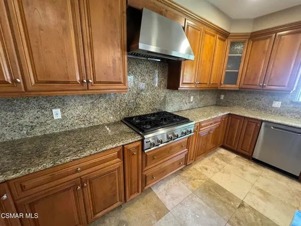 a kitchen with stainless steel appliances granite countertop a sink stove and cabinets