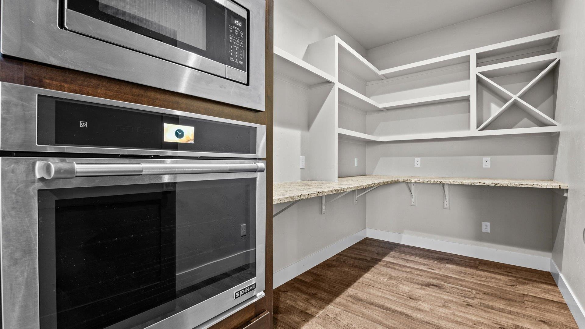 2041 J J 1/2 Road Fruita, CO 81521 - Photo 10 of 42 a view of an empty room with wooden floor and a kitchen