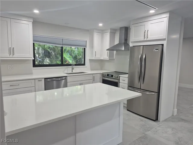a kitchen with stainless steel appliances a refrigerator sink and cabinets