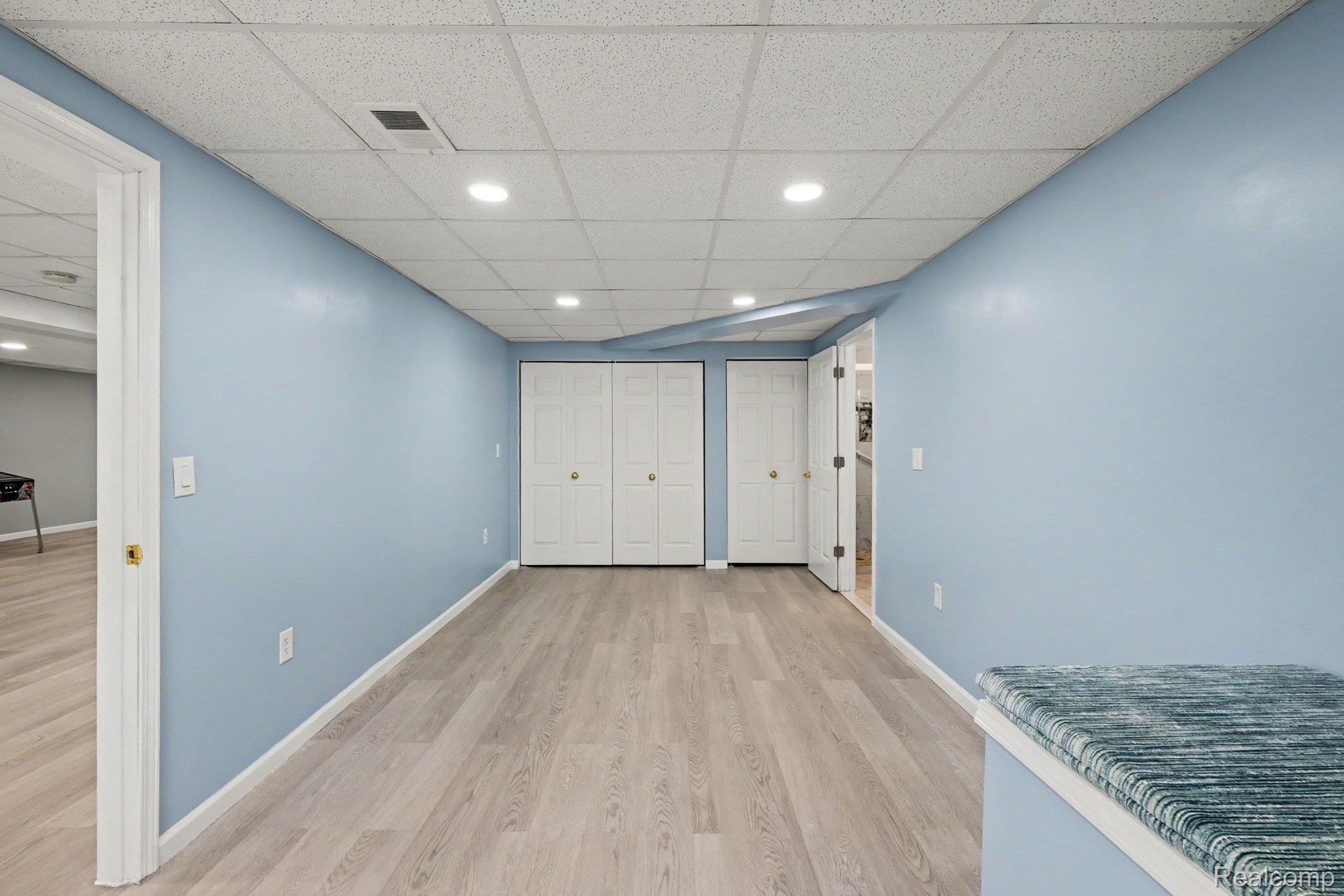 1941 Mapleridge Road Rochester, MI 48309 - Photo 40 of 55 Unfurnished bedroom featuring light wood-style floors, a drop ceiling, recessed lighting, and multiple closets