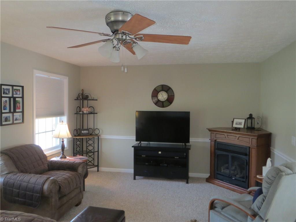 2212 Little Elkin Church Road Ronda, NC 28670 - Photo 13 of 30 Living room with gas log fireplace and ceiling fan.