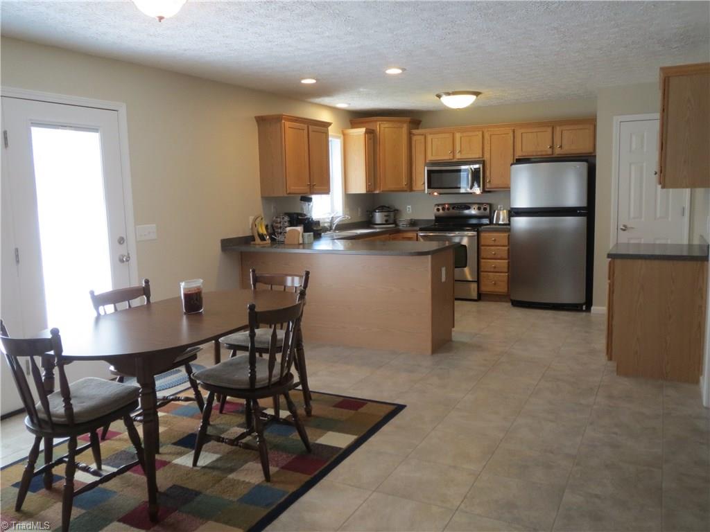 2212 Little Elkin Church Road Ronda, NC 28670 - Photo 14 of 30 Spacious kitchen features tile floor, stainless steel appliances and pantry for ample storage.