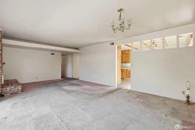 a view of a big room with windows and chandelier fan