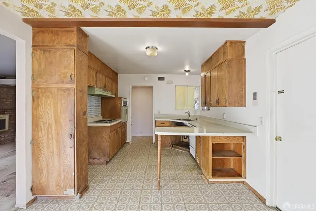 a kitchen with a sink a counter top space and stainless steel appliances
