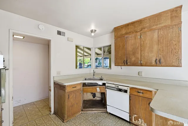 a utility room with a sink a stove and a window