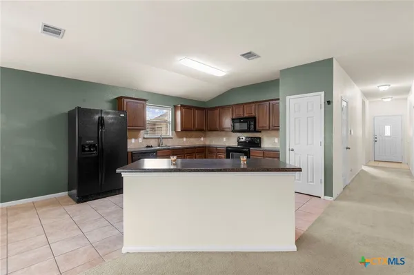 a kitchen with stainless steel appliances granite countertop a refrigerator and a stove