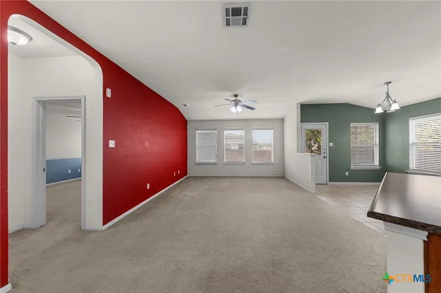 en empty room with windows and ceiling fan