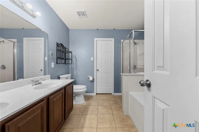 a bathroom with a sink a toilet a mirror and shower