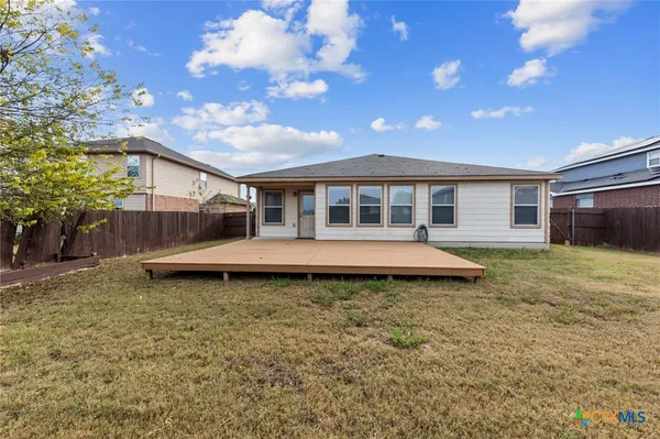 a view of a house with a yard and wooden fence
