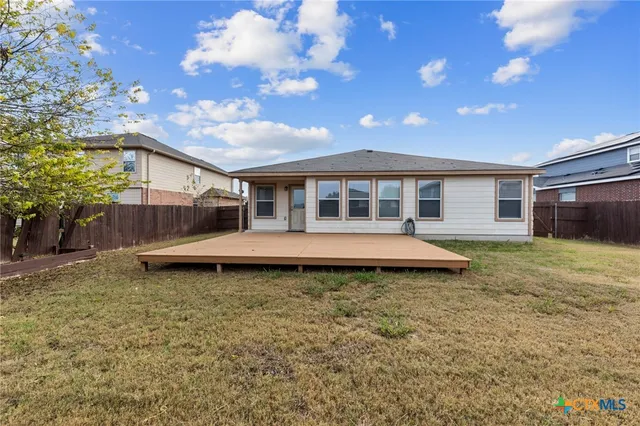 a view of a house with a yard and wooden fence