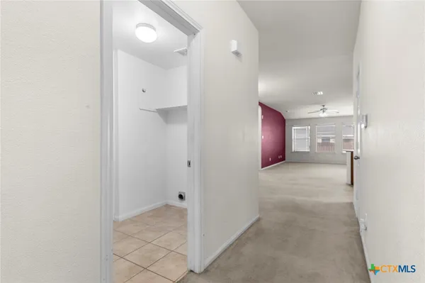 a view of a hallway with wooden shelves
