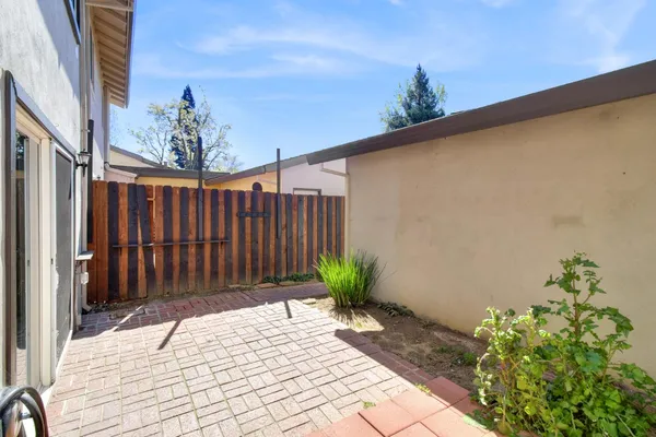 a view of a dining room with furniture a potted plant and wooden floor
