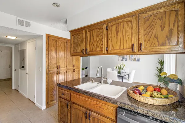a kitchen with granite countertop a stove and a microwave with cabinets