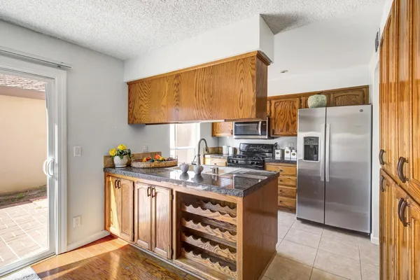 a kitchen with stainless steel appliances granite countertop a refrigerator and a stove