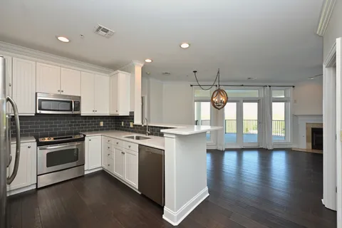 a kitchen with stainless steel appliances granite countertop a stove and a white cabinets