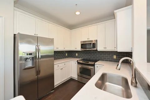 a kitchen with a refrigerator sink and cabinets