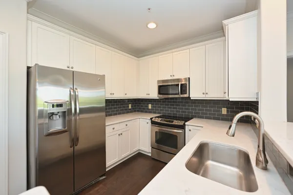 a kitchen with a refrigerator sink and cabinets