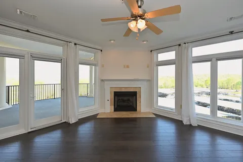 a view of a livingroom with hardwood floor a fireplace and a large window