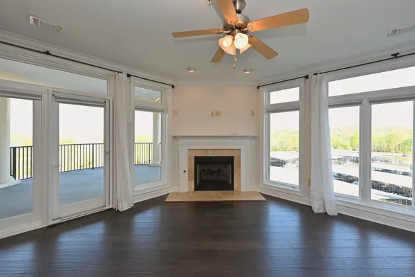 a view of a livingroom with hardwood floor a fireplace and a large window