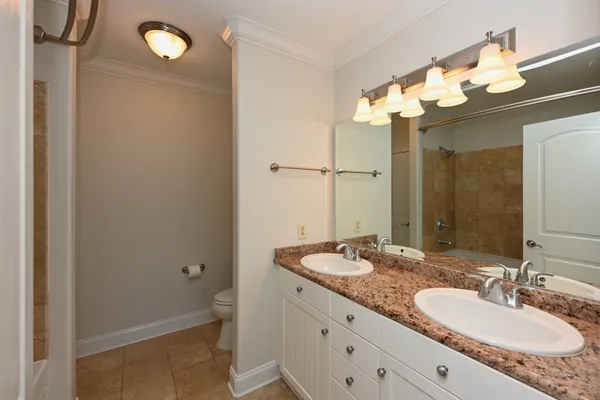 a bathroom with a granite countertop sink a toilet and a mirror