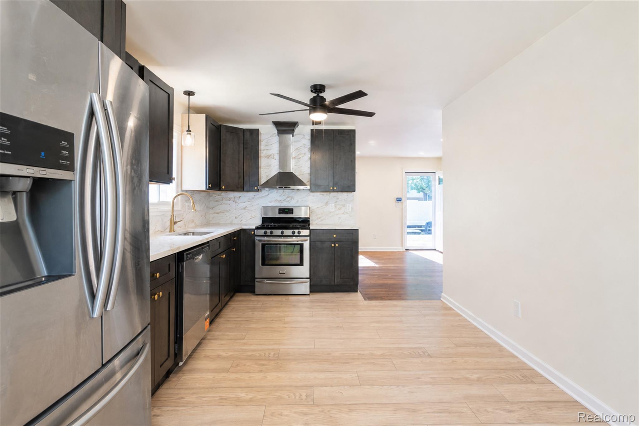 201 Cardwell Street Inkster, MI 48141 - Photo 13 of 41 Modern kitchen featuring stainless steel appliances, dark wood-finish cabinetry, a large refrigerator, white countertops, and a full backsplash