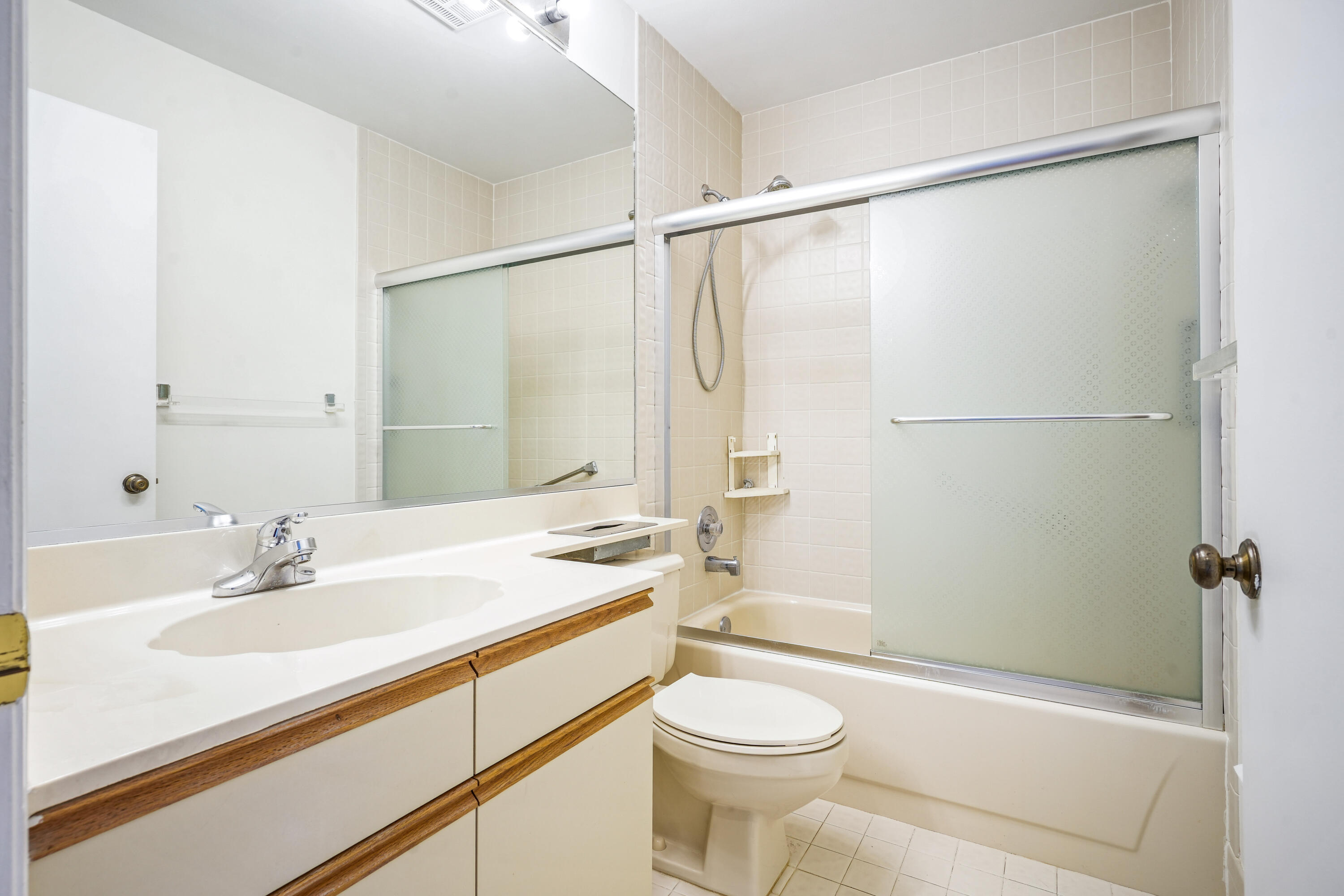 10910 Lakemore Lane, Unit 201 Boca Raton, FL 33498 - Photo 22 of 67 a bathroom with a sink a mirror and a toilet