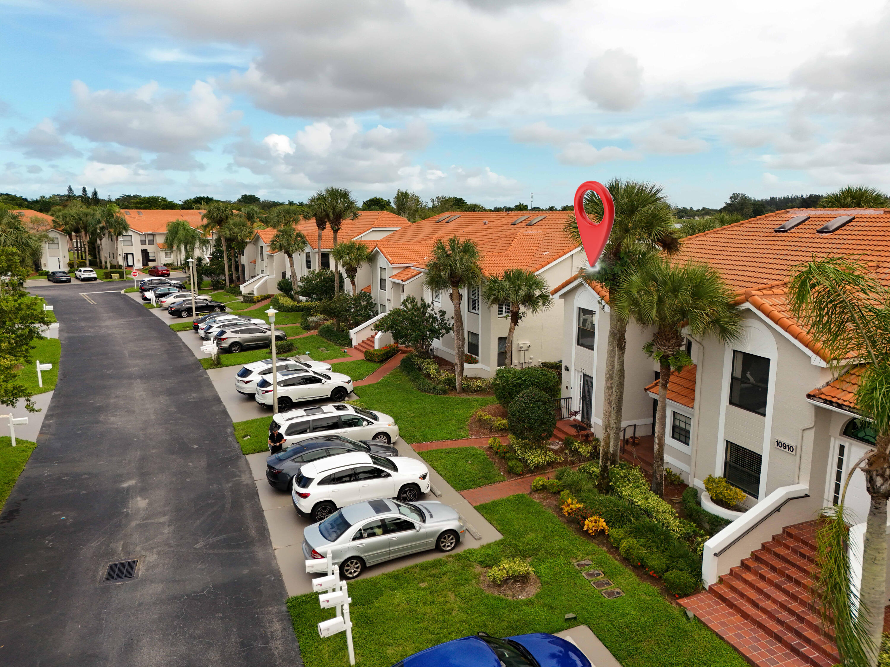 10910 Lakemore Lane, Unit 201 Boca Raton, FL 33498 - Photo 58 of 67 a view of a white house with a yard and outdoor seating