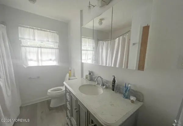 a bathroom with a sink toilet and window