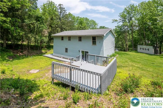 a view of a house with a yard deck and furniture