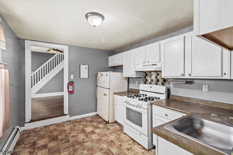 636 Elizabeth Street Beverly, NJ 08010 - Photo 14 of 15 a kitchen with white cabinets and white appliances