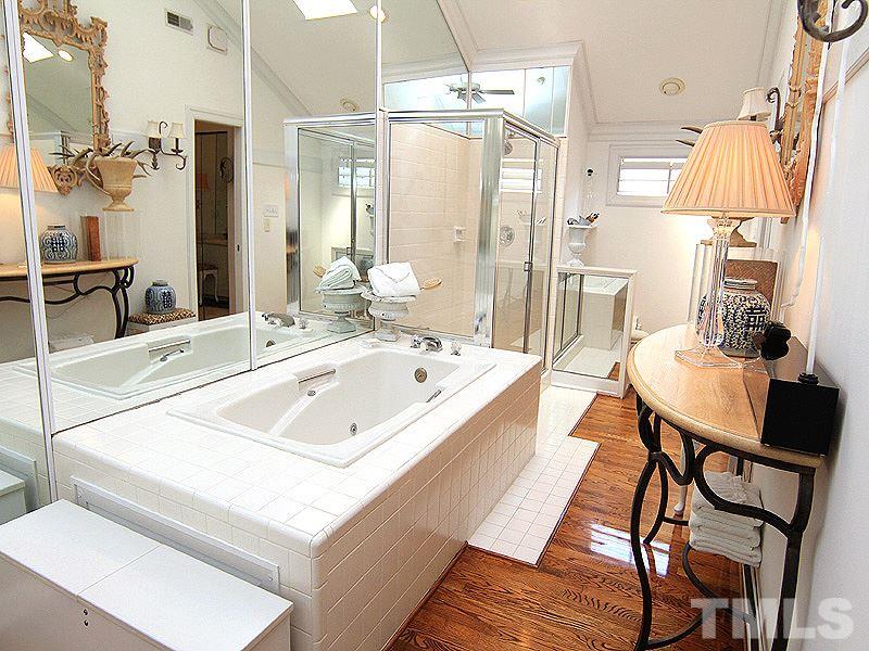 6906 Hunters Way Raleigh, NC 27615 - Photo 22 of 25 a bathroom with a sink mirror and a bathtub