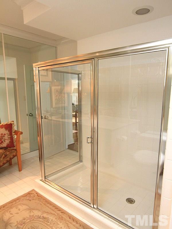 6906 Hunters Way Raleigh, NC 27615 - Photo 25 of 25 a bathroom with a glass shower door