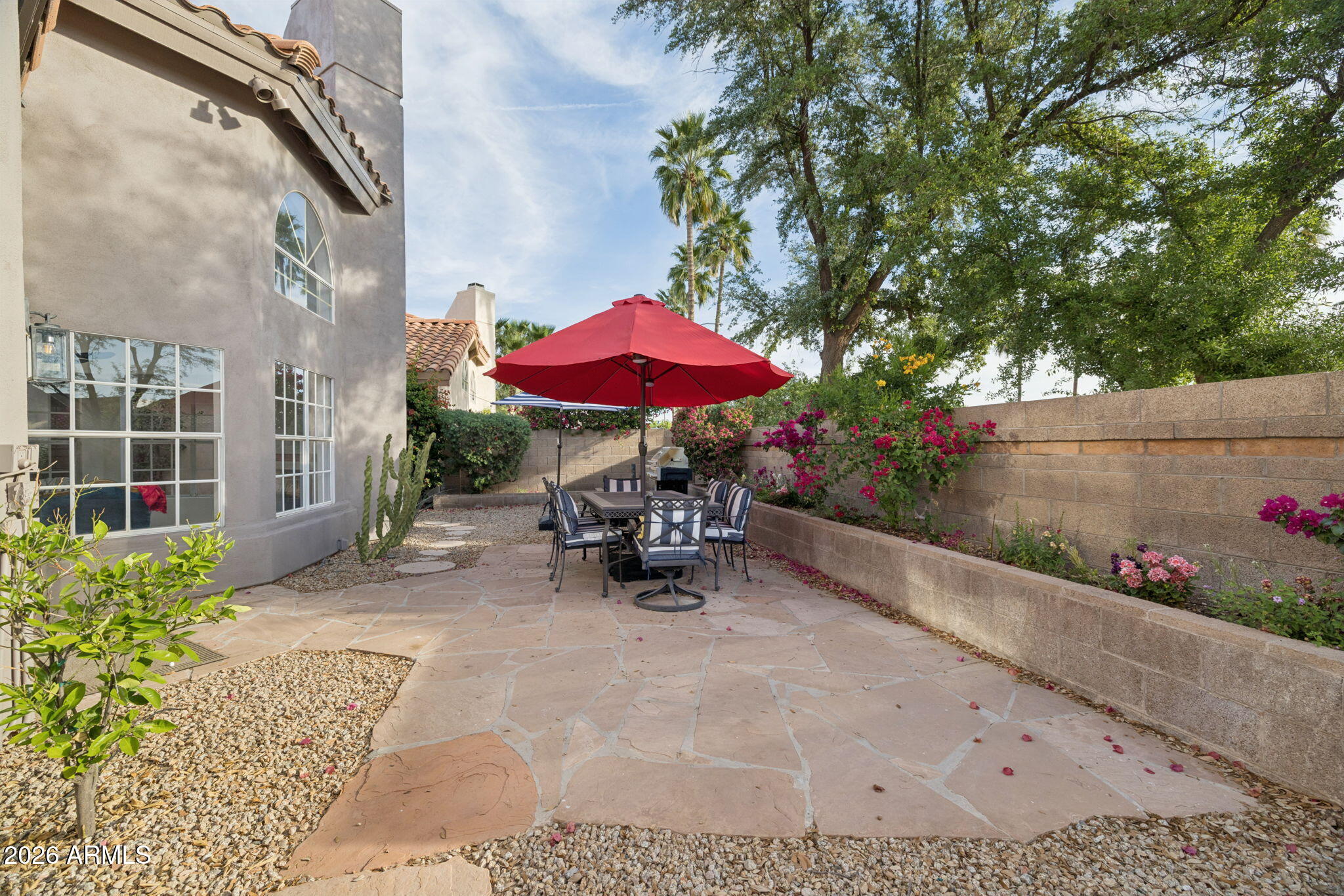 16409 South 33rd Street Phoenix, AZ 85048 - Photo 50 of 61 a view of a patio with a table and chairs under an umbrella with potted plants