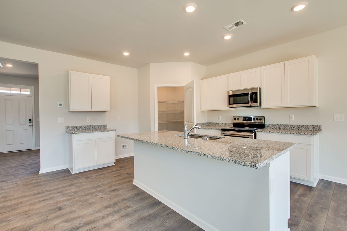 275 Harris Lane Baxter, TN 38544 - Photo 7 of 26 a kitchen with a sink a stove a microwave a center island and a window