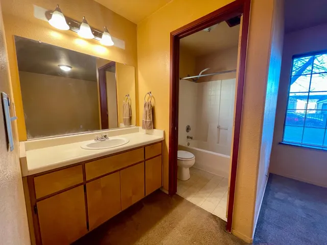 a bathroom with a double vanity sink toilet and shower