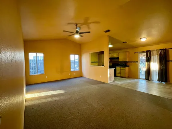 a view of empty room with a kitchen