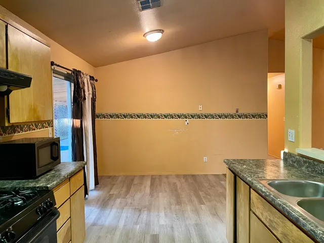 a view of a kitchen with a sink and wooden floor