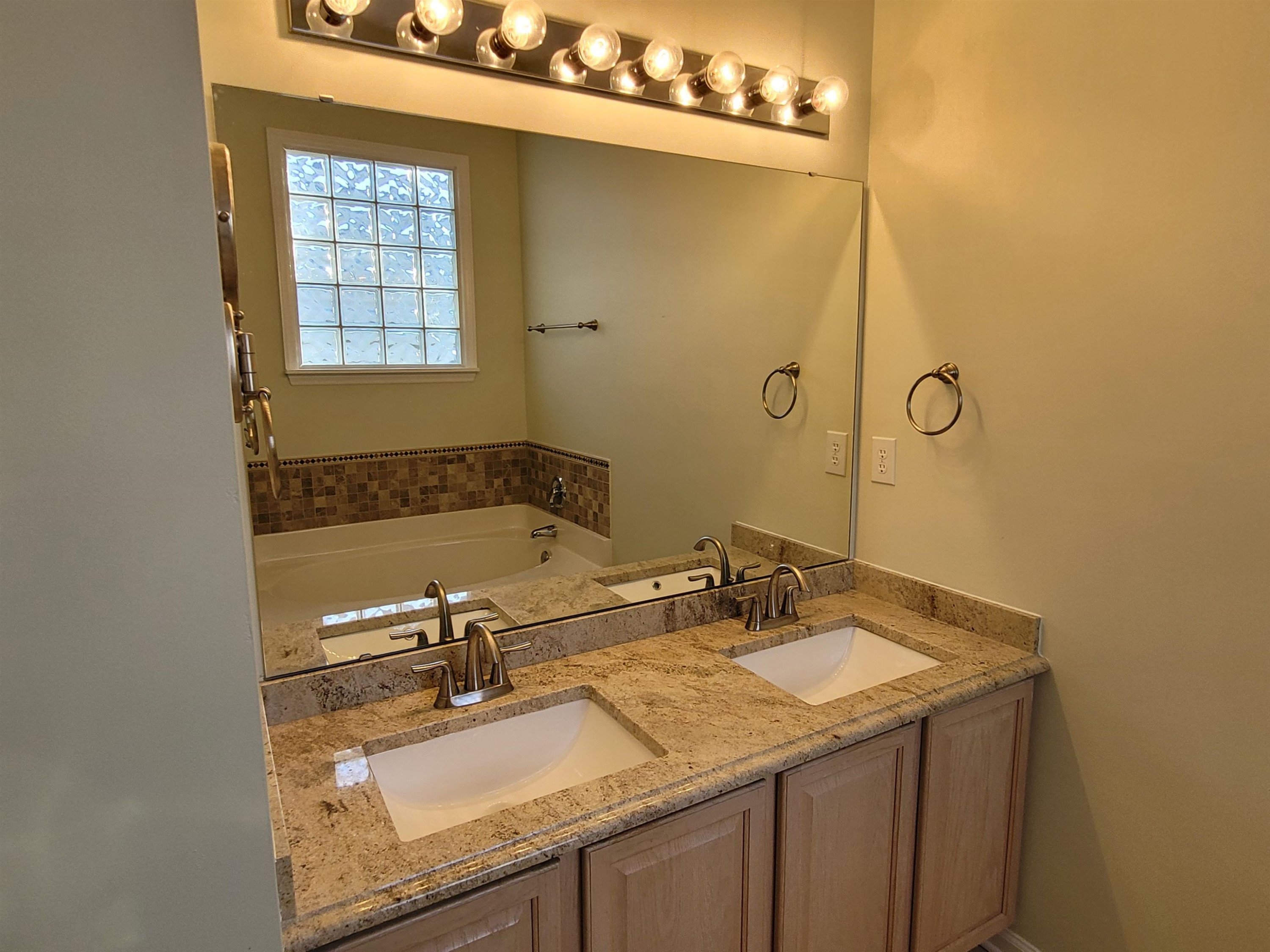 7 Calaveras Court Durham, NC 27713 - Photo 17 of 30 a bathroom with a granite countertop sink a mirror and a bathtub