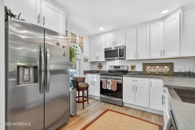 a kitchen with a refrigerator a microwave a stove and cabinets
