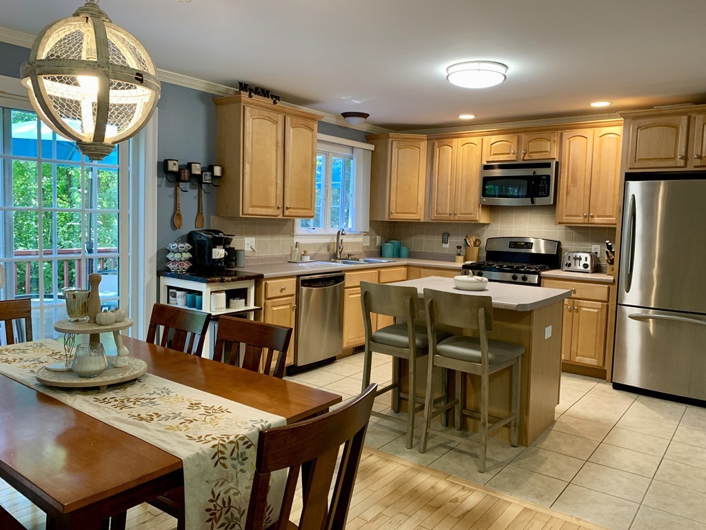 130 Turnpike Road, Unit 13 Chelmsford, MA 01824 - Photo 1 of 35 a kitchen with stainless steel appliances granite countertop a stove a refrigerator a kitchen island a dining table and chairs