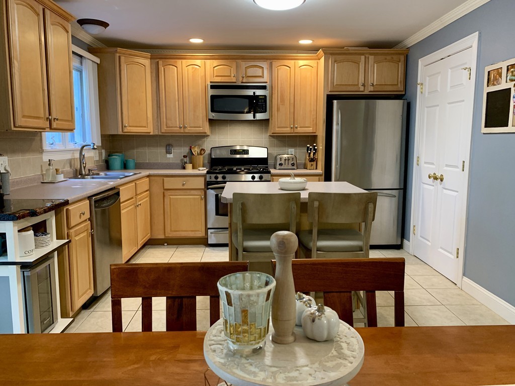 130 Turnpike Road, Unit 13 Chelmsford, MA 01824 - Photo 3 of 35 a kitchen with a table chairs a refrigerator and a stove