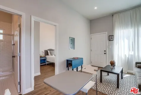 a living room with stainless steel appliances furniture and a kitchen view
