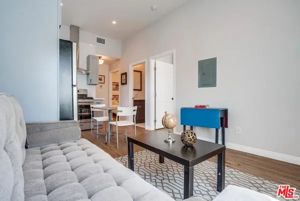 a kitchen with stainless steel appliances a stove a sink refrigerator and a white cabinets